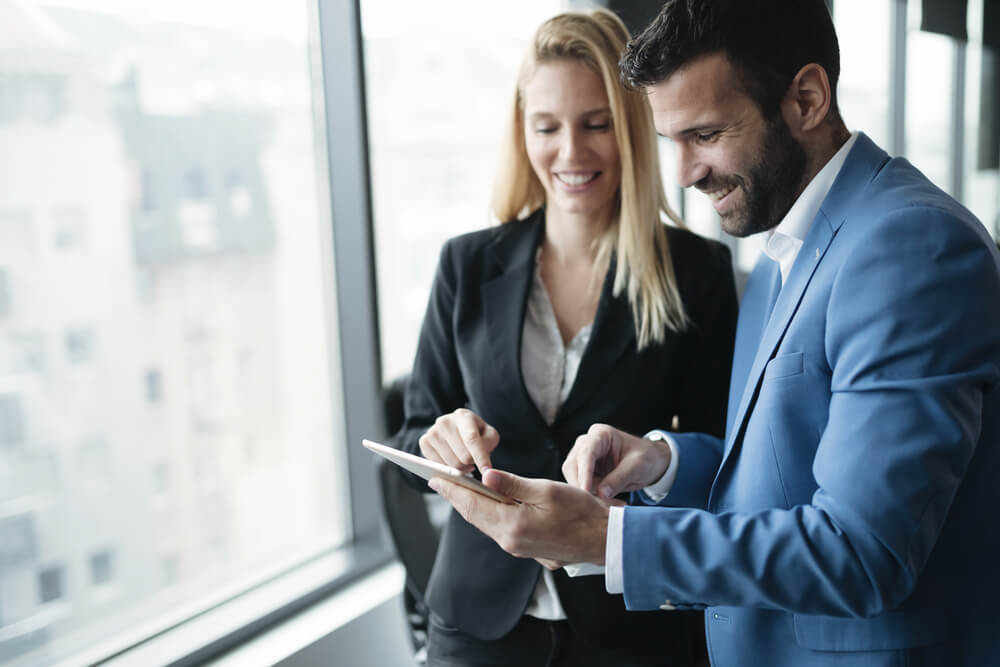 Financial advisor reviewing a plan with a client on a tablet